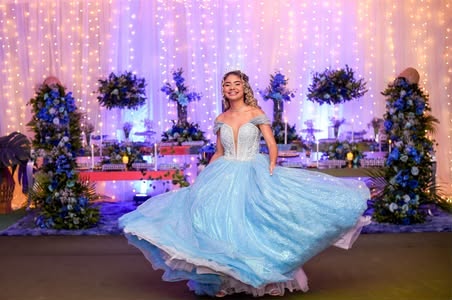 Debutante girando o vestido azul na pista, diante da decoração com flores azuis